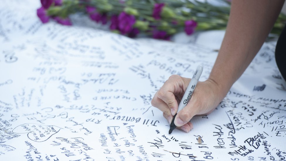 2015-06-20. Представители общественности подписали большой лист соболезнования перед церковью Эмануэля AME в субботу вечером, где девять прихожан были убиты тремя днями ранее. Колм О'Моллой для BBC News.