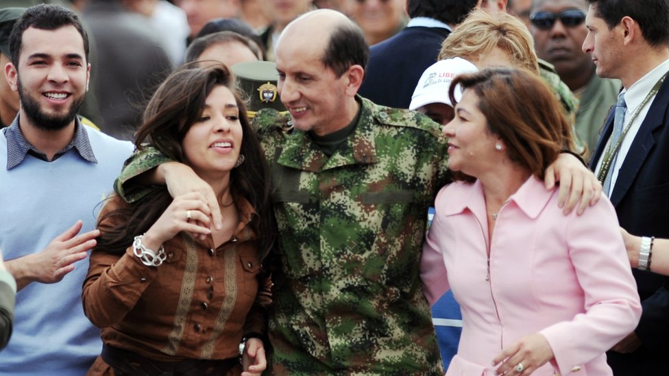 Бывший заложник Революционных вооруженных сил Колумбии (FARC) генерал Луис Херлиндо Мендьета (C) обнимает свою семью по прибытии в Боготу 14 июня 2010 года.