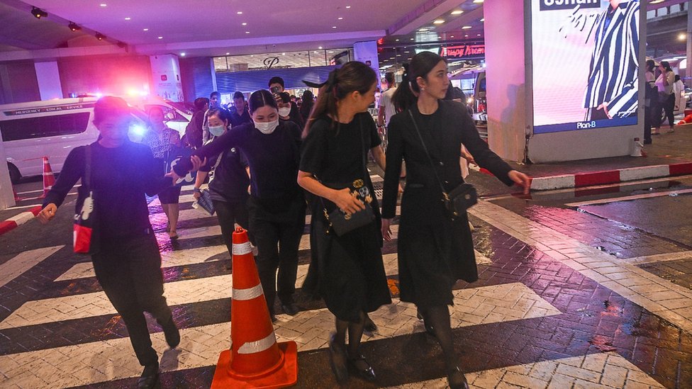 People exit the Siam Paragon mall as a shooting incident was still ongoing inside on October 03, 2023 in Bangkok, Thailand