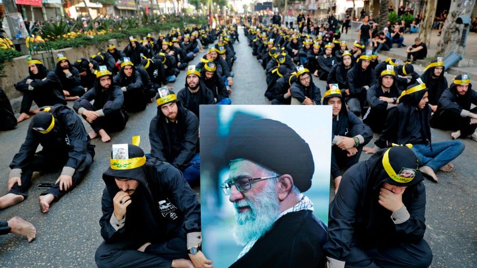 Supporters of the Lebanese Shia Hezbollah movement hold a picture of Iran's Supreme Leader Ayatollah Ali Khamenei as they take part in a religious mourning procession in Beirut, on September 10, 2019