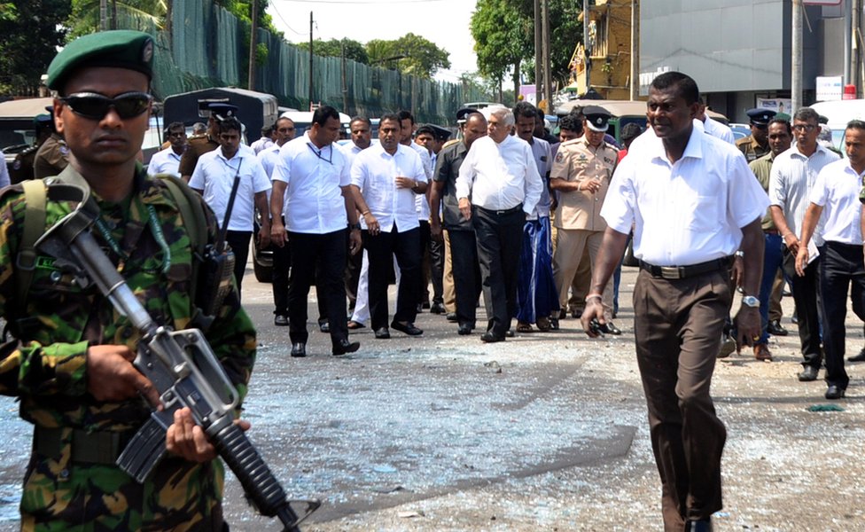 Sri Lankan Prime Minister Ranil Wickremesinghe (C-R) arrives at the scene after an explosion at St Anthony's Church in Kochchikade in Colombo