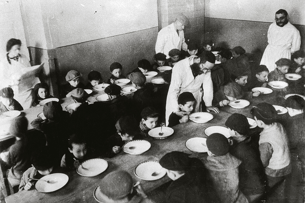 Niños comiendo en un comedor comunitario en el gueto de Varsovia