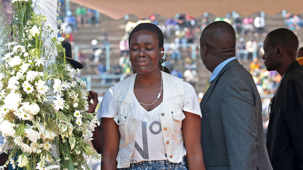 Женщина плачет при публичном осмотре тела покойного бывшего президента Зимбабве Роберта Мугабе в гробу, когда оно лежит в государстве в Хараре, Зимбабве, 13 сентября 2019 года.