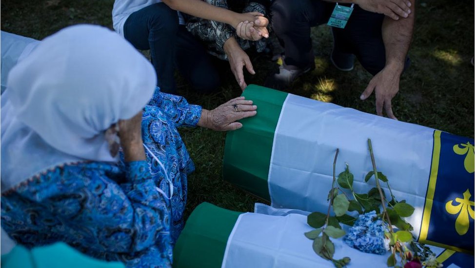 Žena drži glavu u rukama pored tabuta, Potočari 2018