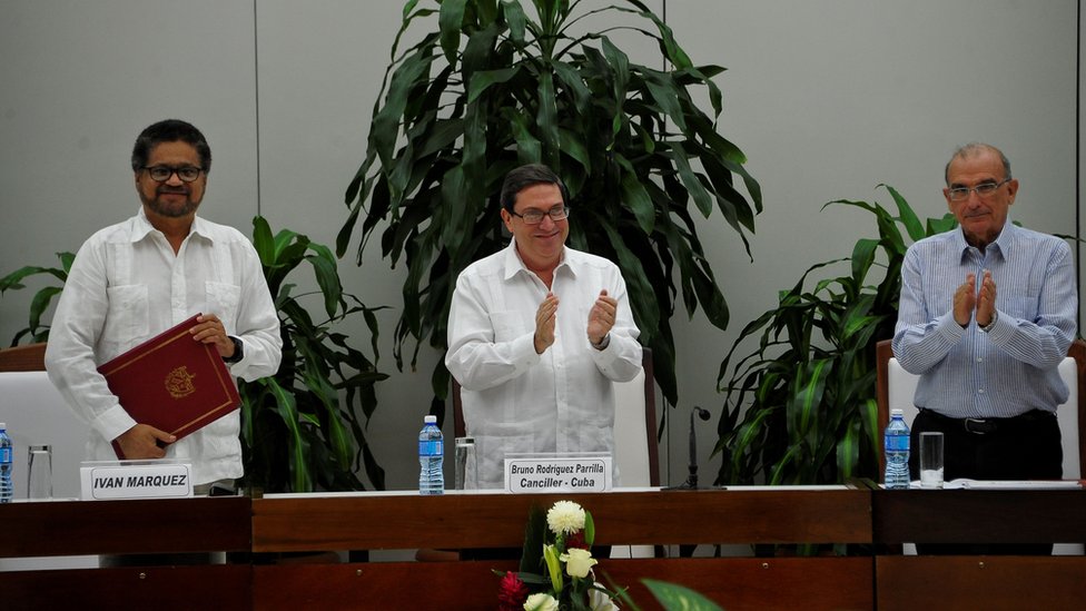 Министр иностранных дел Кубы Бруно Родригес Паррилья (в центре) аплодирует после того, как командующий левыми партизанами РВСК-НА Иван Маркес (слева) и глава колумбийской делегации на мирных переговорах Умберто де ла Калле (справа) подписали новое мирное соглашение в Гаване в ноябре. 12, 2016.