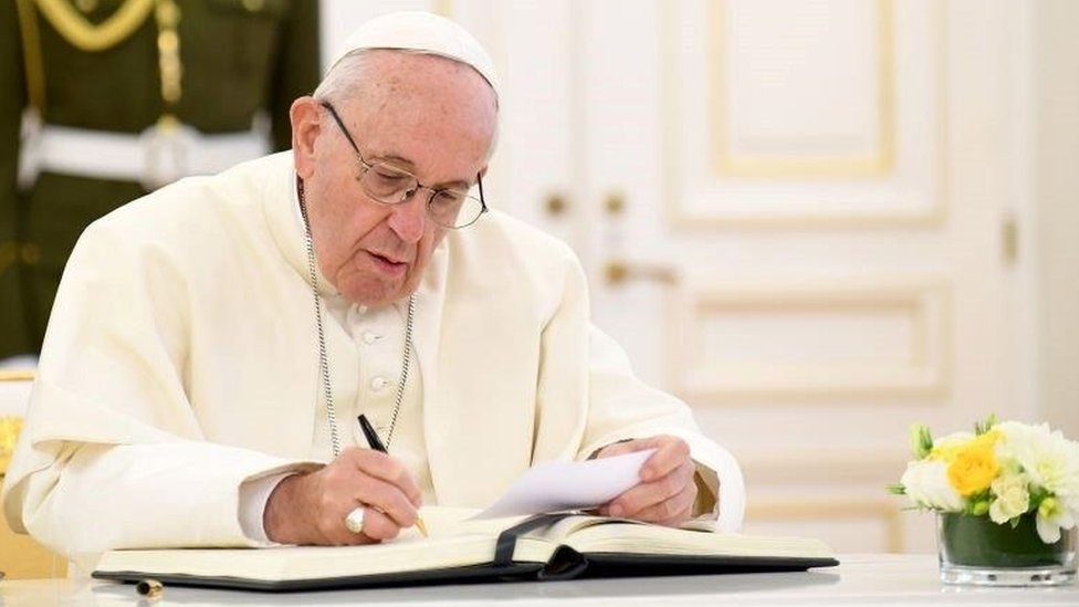 Pope Francis signing a document