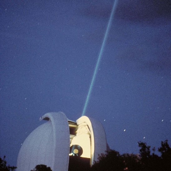 Telescopio del Observatorio McDonald enviando un rayo láser a la Luna