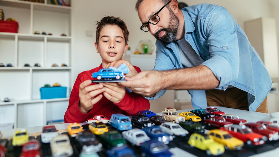 Father and son with a collection of cars