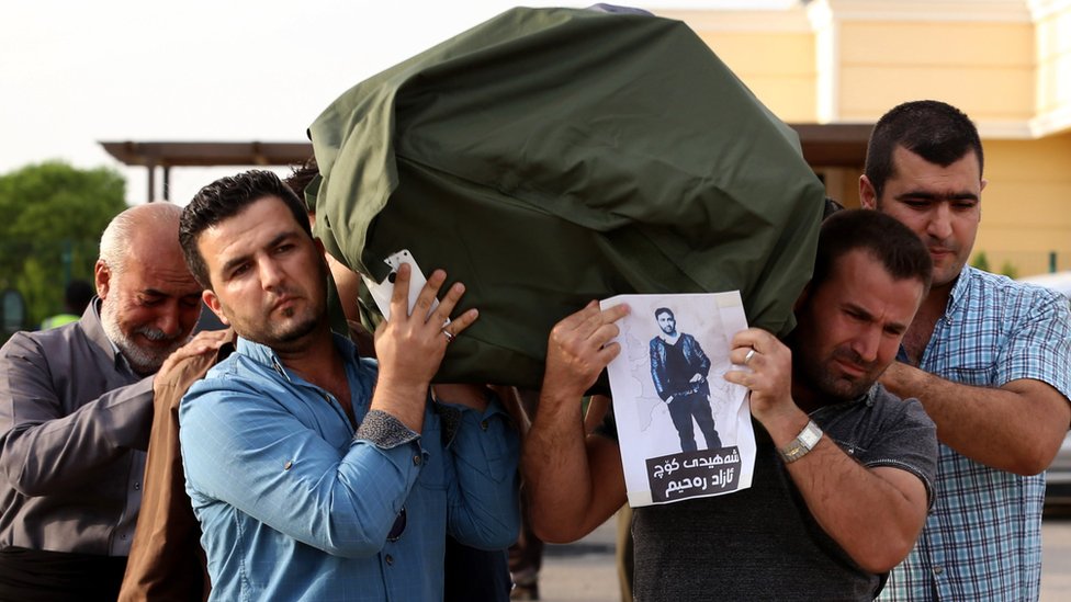 Iraqi Kurdish men carry the coffin of a Kurdish migrant, who died in a lorry in Austria alongside other migrants in 2015