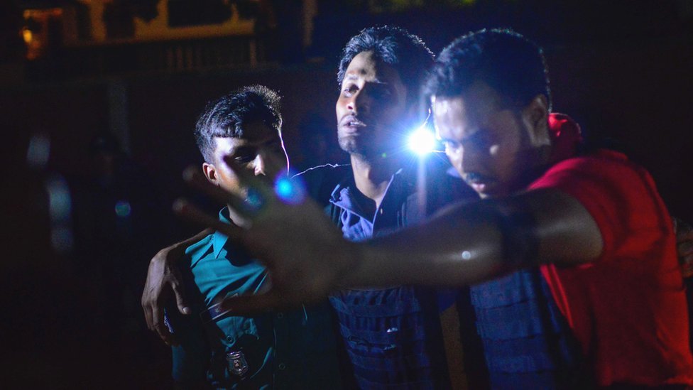 Бангладешскому полицейскому, который был ранен во время нападения на престижный ресторан, помогают другие в Дакке 1 июля 2016 года.