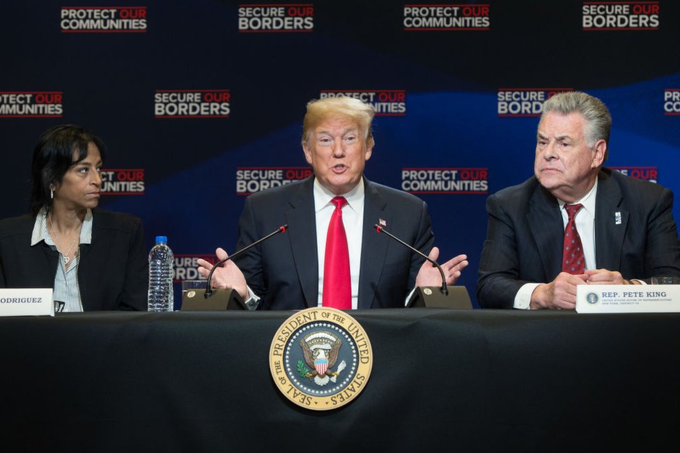 Donald Trump entre el congresista republicano Peter King y Evelyn Rodríguez, cuya hija fue asesinada por pandilleros de la MS-13, durante , un debate sobre migración en Nueva York el 23 de mayo de 2018.