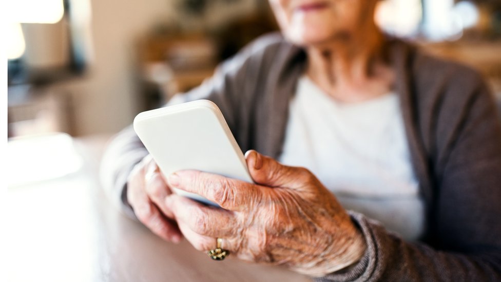 Mulher idosa usando celular