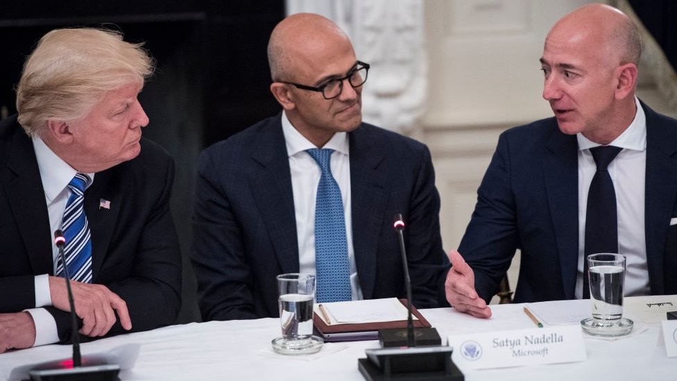 Президент Дональд Трамп беседует с Сатья Наделла, генеральным директором Microsoft, и Джеффом Безосом, главным исполнительным директором Amazon во время круглого стола Американского технологического совета в столовой штата Белого дома в Вашингтоне, округ Колумбия, в понедельник, 19 июня 2017 года.