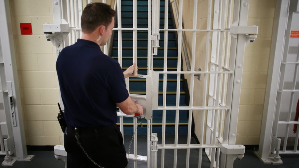 Тюремный офицер запирает ворота