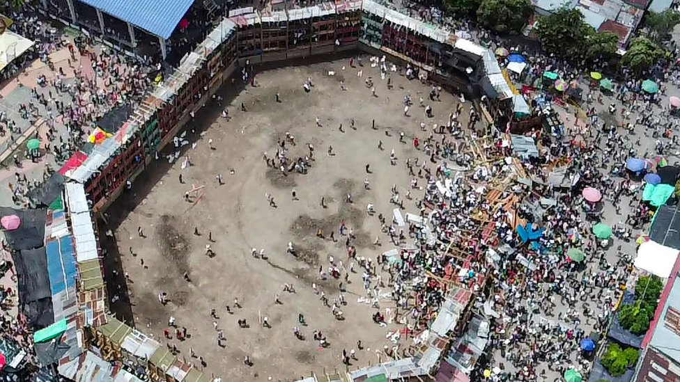 Foto aérea de plaza de toros de madera, con una tribuna derrumbada.