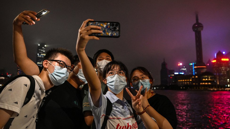 上海外灘一群男女以關上景觀燈光的浦東為背景拍照（23/8/2022）