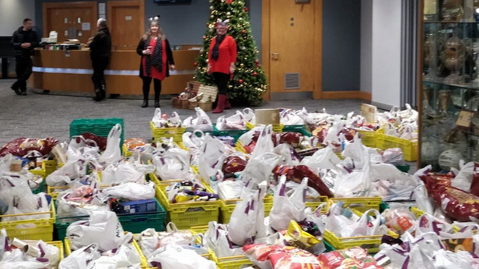 Каждый заслуживает рождественские корзины, готовые к доставке, на заднем плане - член парламента Кэролайн Харрис