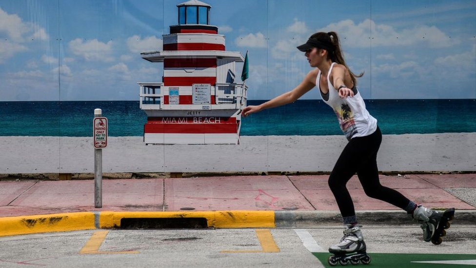 Una mujer patina junto a la playa en Miami.