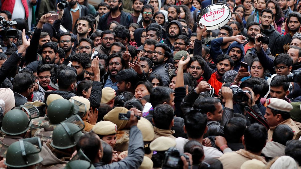 Демонстранты присутствуют на акции протеста против нападений на студентов Университета Джавахарлала Неру (JNU) в воскресенье в университетском городке Нью-Дели