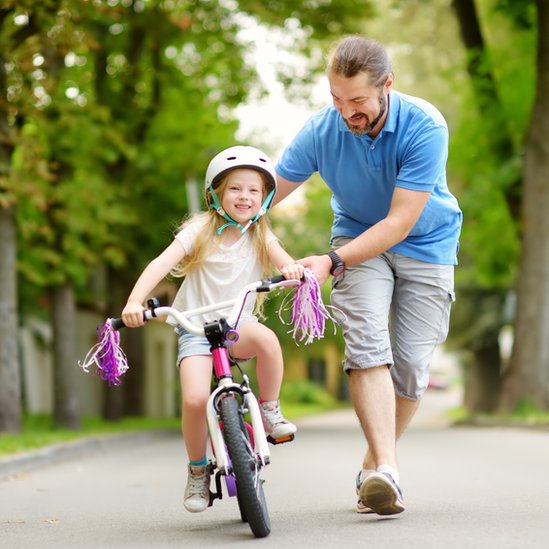 Padre y niña en bicicleta.