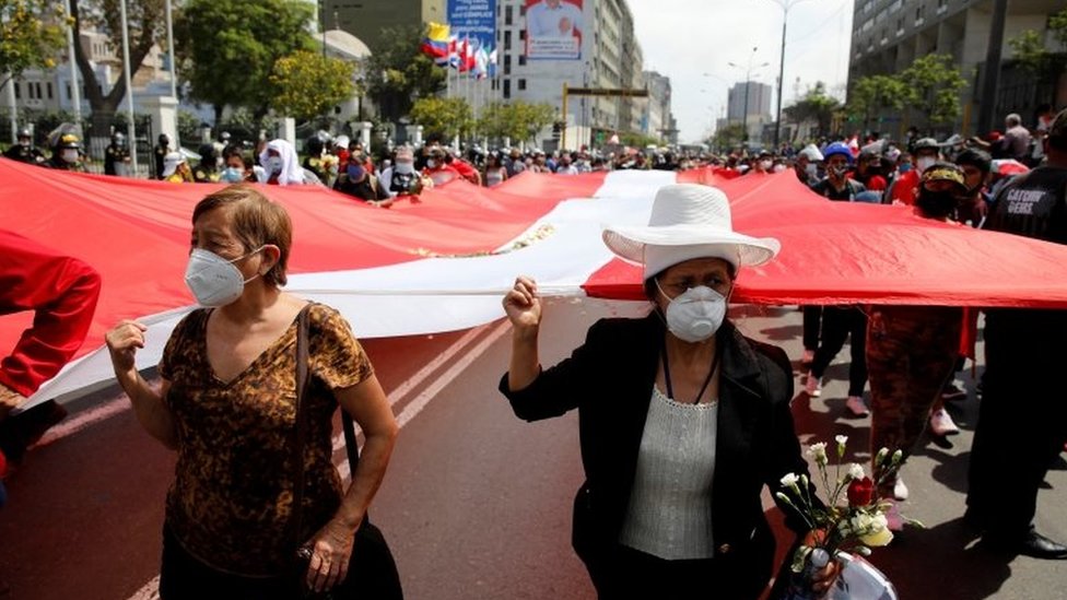 Dos mujeres sujetan una bandera peruana en medio de una gran manifestación en Lima, el 16 de noviembre de 2020.