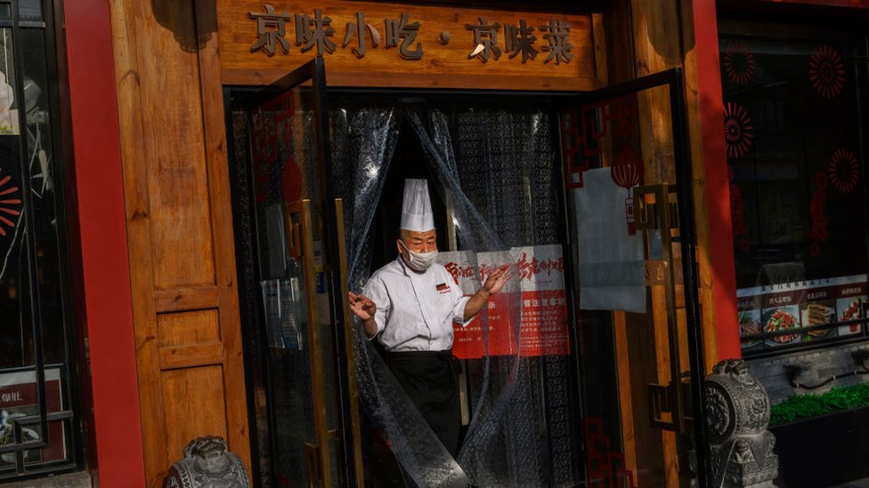 Un cocinero en la puerta de un restaurante con mascarilla en Pekín, el 2 de mayo.