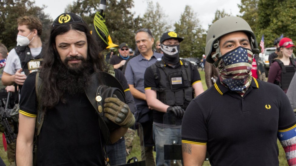 Proud boys vestem camisa polo preta com duplas de faixas amarelas