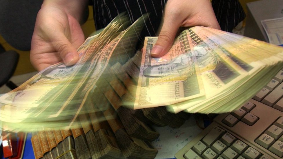 Hands holding money at a foreign exchange in the Philippines