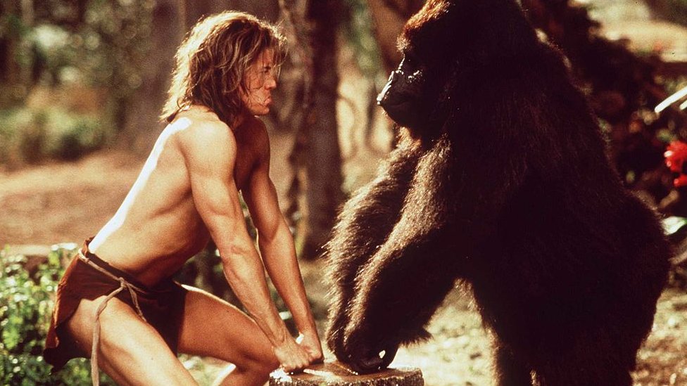 Fotograma de la película George de la Jungal donde se ve a Fraser en culillas frente a un gorila.
