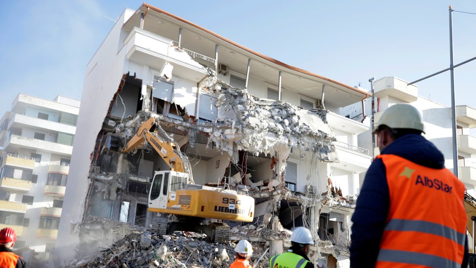A bulldozer works at a collapsed building in Durres
