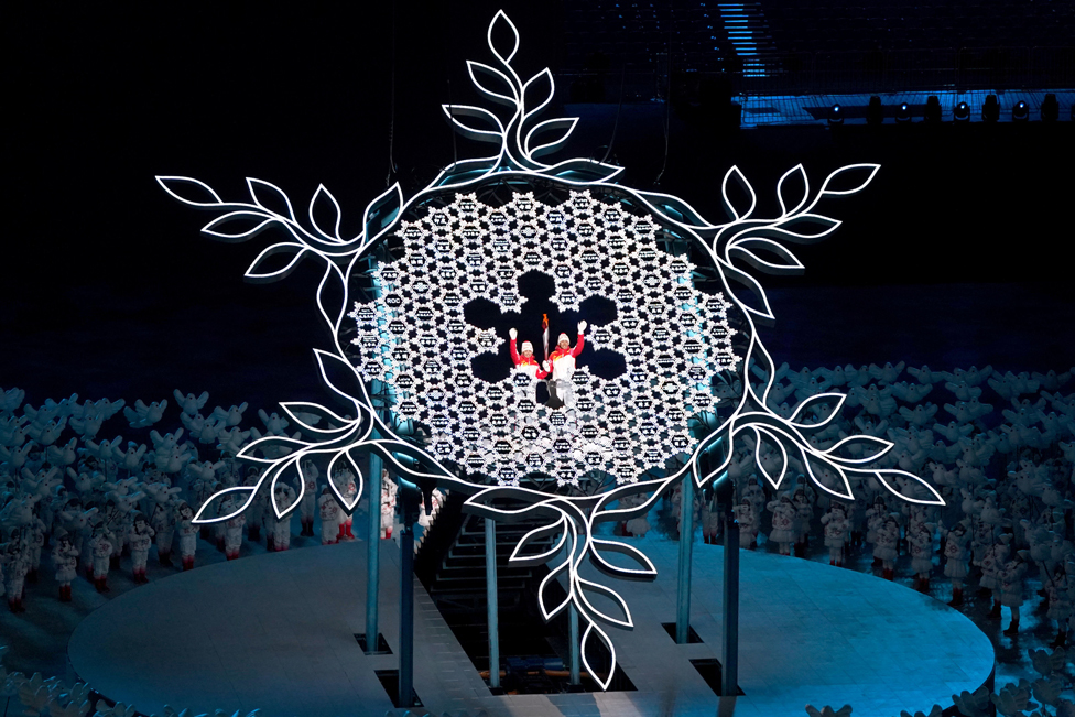 حاملتا شعلة دورة الألعاب الأولمبية الشتوية في بكين، تلوحان للجمهور قبل إشعال المرجل الأولمبي خلال حفل افتتاح دورة 2022 في استاد بكين الوطني في الصين