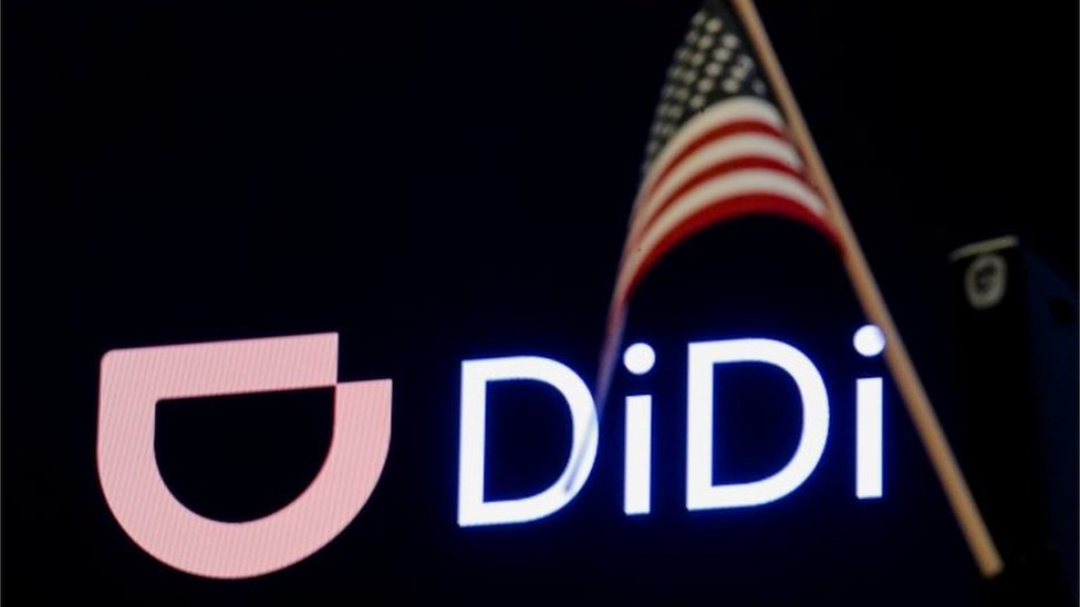 An American flag is seen in front of the logo for Chinese ride hailing company Didi Global Inc. during the IPO on the New York Stock Exchange (NYSE) floor in New York City, U.S., June 30, 2021