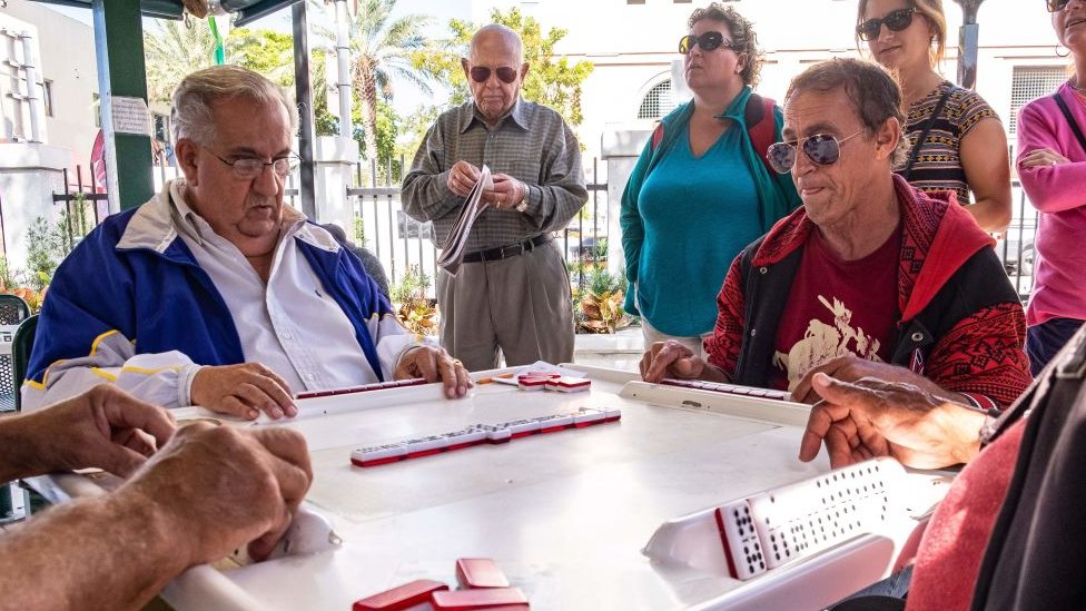 Cubanos juegan dominó en la Calle 8 de Miami.