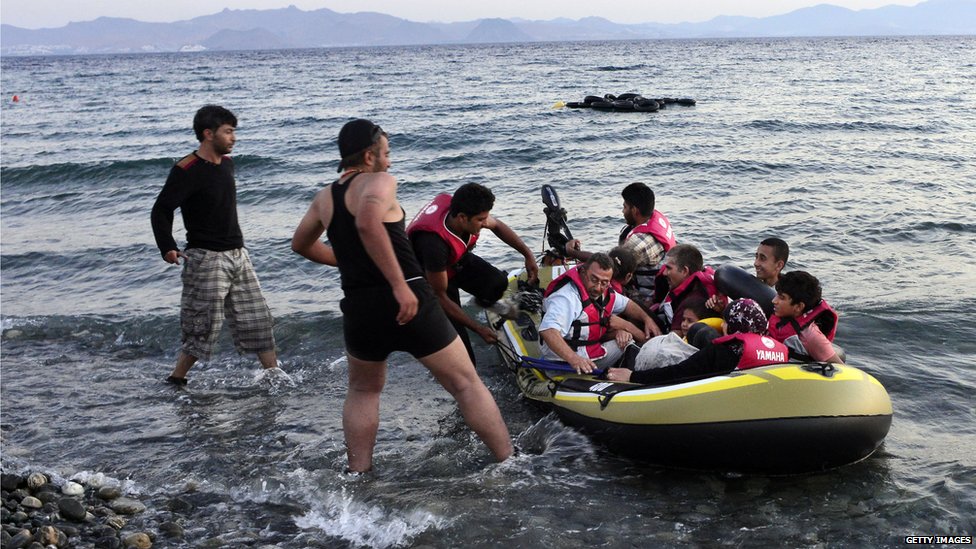 Маленькая лодка, переполненная сирийскими мигрантами, приближается к пляжу на греческом острове Кос после пересечения части Эгейского моря из Турции в Грецию на лодке 13 августа 2015 года в Косе, Греция