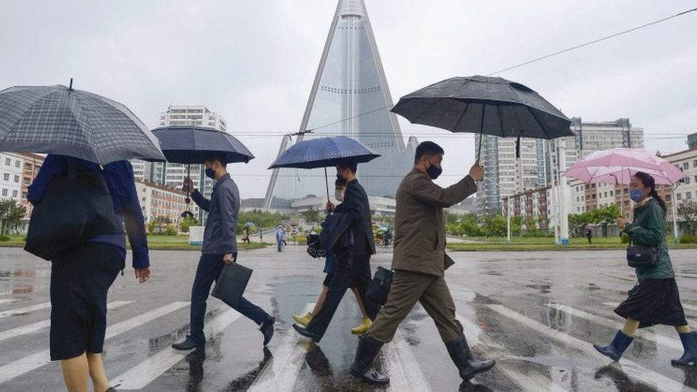 Люди в масках на улицах Пхеньяна, Северная Корея. Фото файла
