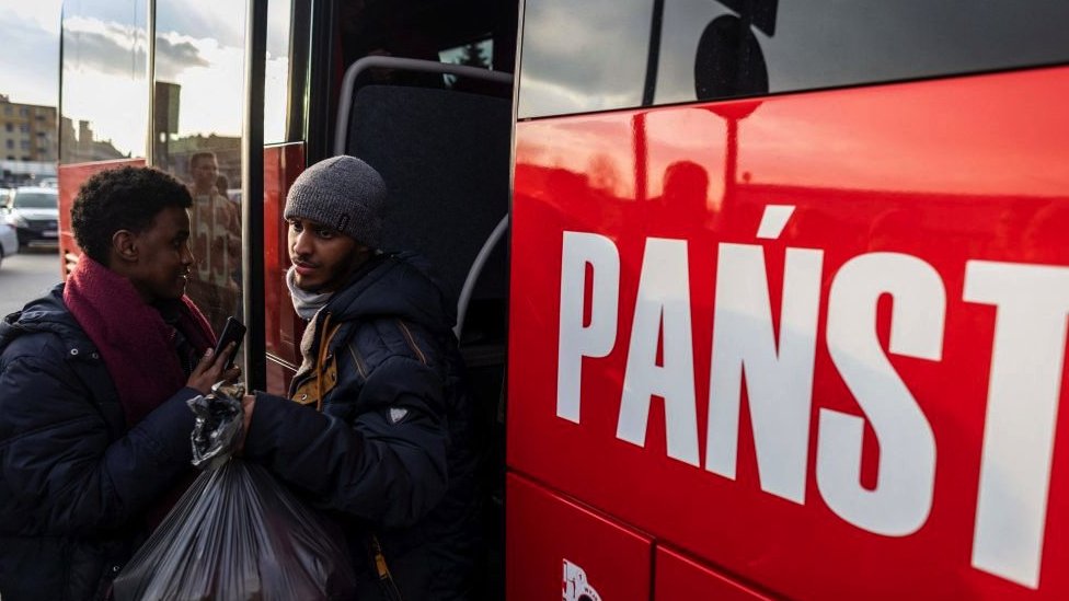 Refugiados abordan un autobús en la frontera polaca.