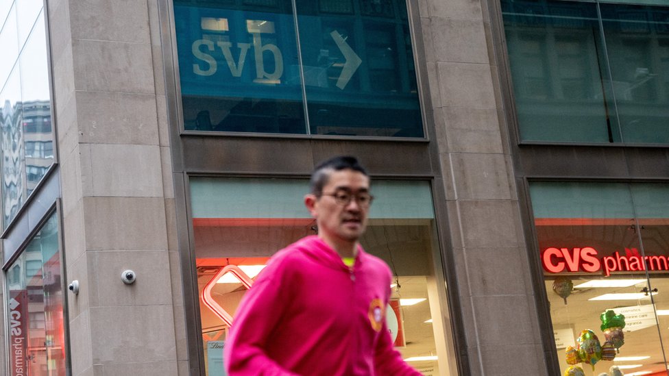 Una persona cruza por delante de una fachada con el cartel del SVB