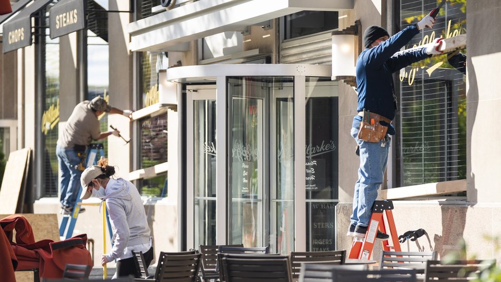Рабочие заколачивают окна в ресторане Вашингтона накануне дня выборов