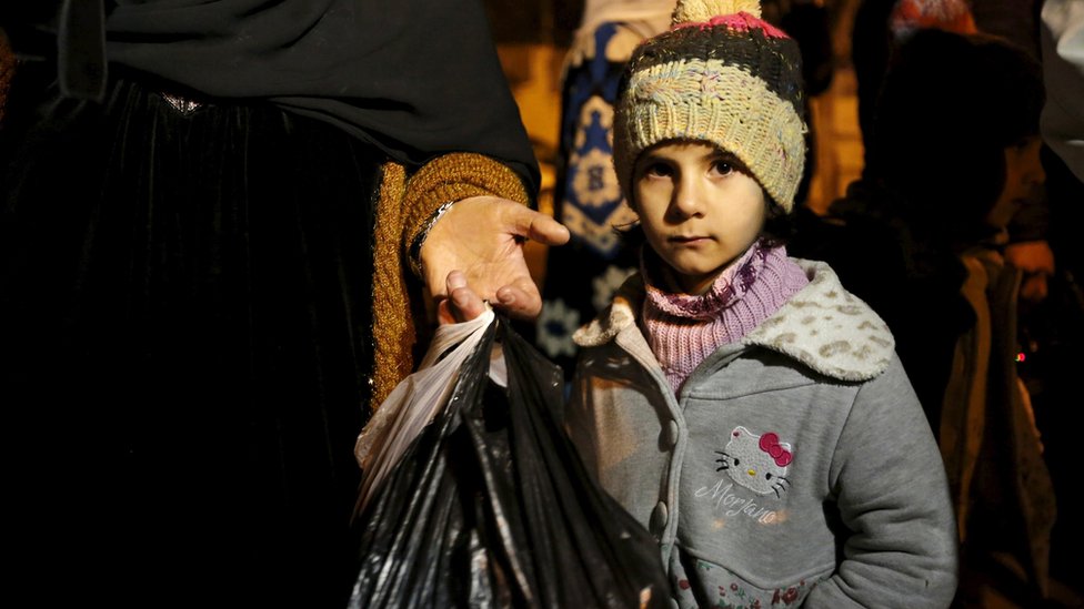 A Syrian girl waits with her family after an aid convoy entered Madaya, Syria January 11, 2016