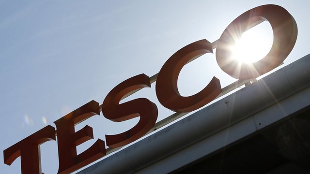 Tesco sign with sun behind it