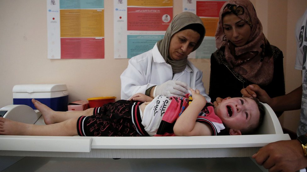 طفل فلسطيني يخضع لفحص طبي من قبل طاقم تابع للأونروا
