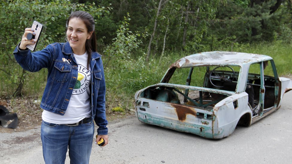 Devojka se slika ispred olupnije automobila u Zabranjenoj zoni i Černobilju