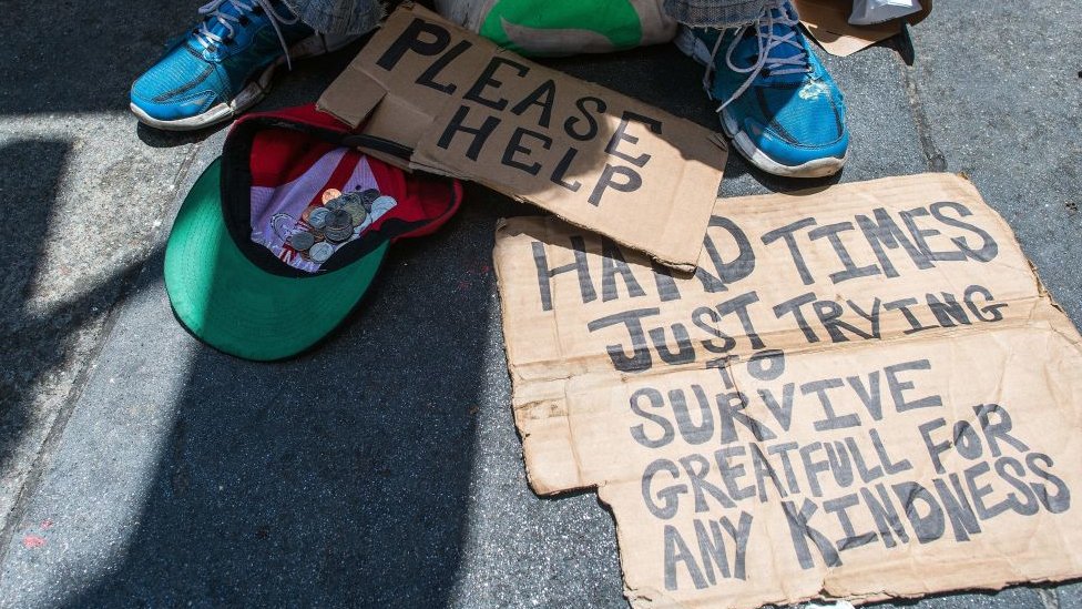Бездомный клянчат деньги с табличками «пожалуйста, помогите» и «тяжелые времена, просто пытается выжить».