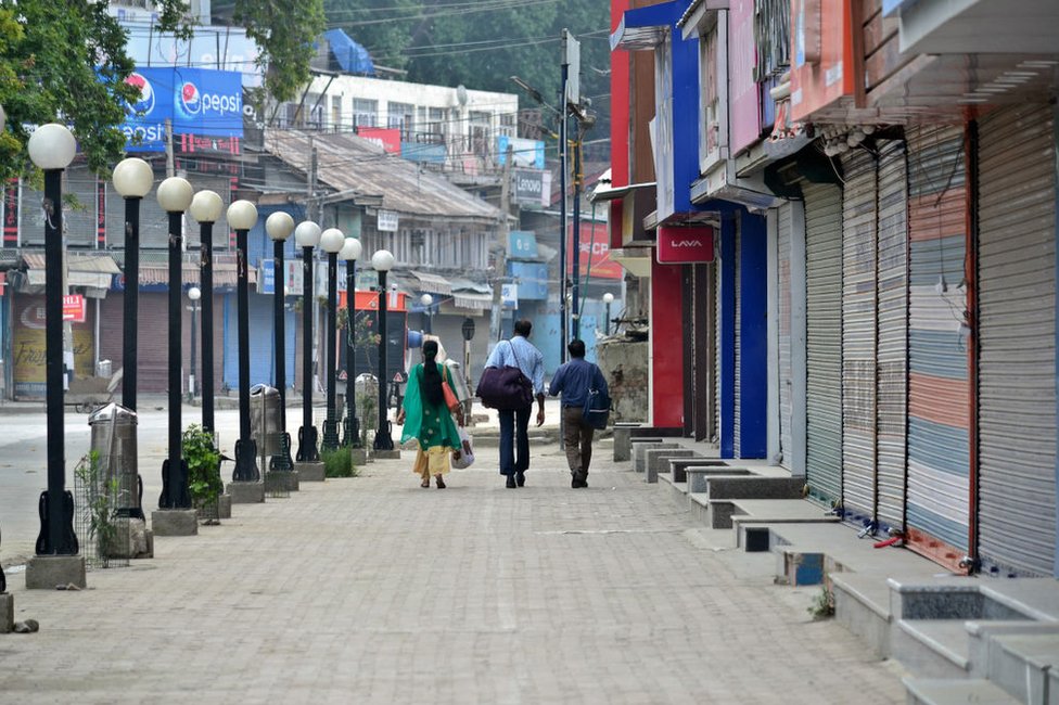Индийские туристы покидают город во время комендантского часа в Сринагаре 16 августа 2019 года.