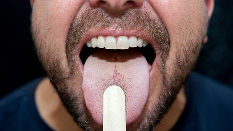 Man sticking out his tongue during an examination