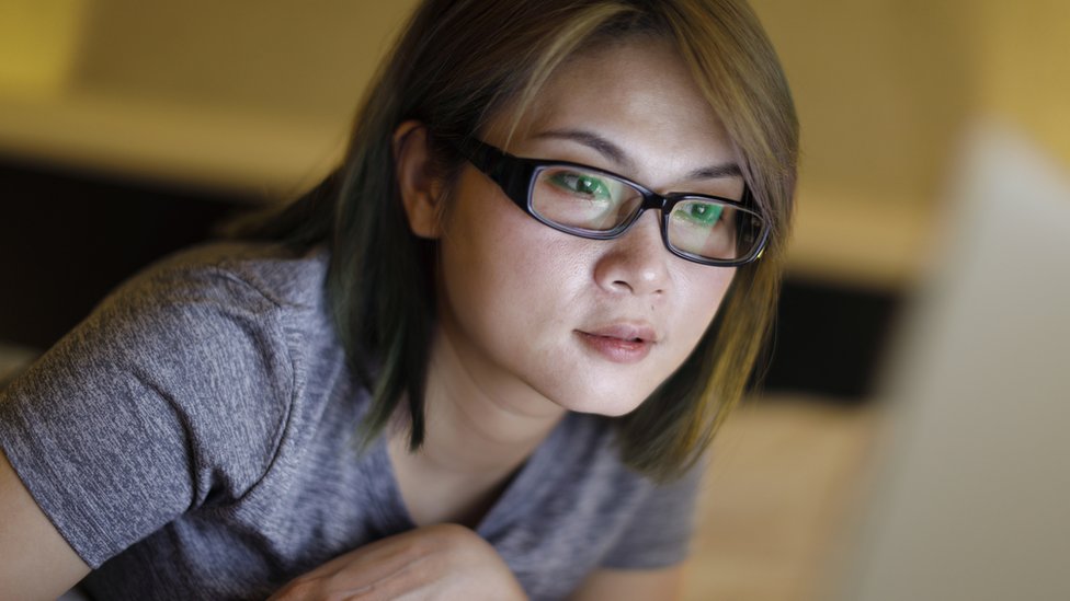 Una joven china mirando una pantalla.