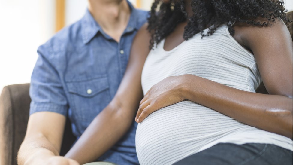 Беременная чернокожая женщина и ее партнер