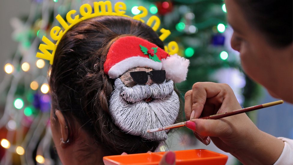 Hindistan'ın Ahmedabad kentinde bir kuaför, 2019 kutlaması için müşterilerinin saçlarına Noel Baba figürleri yapıyor