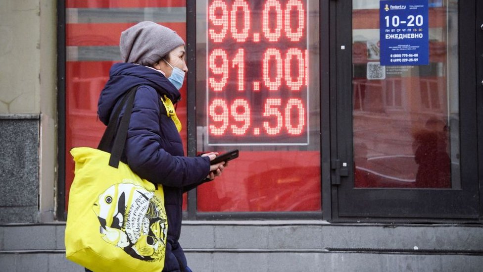 A woman walking past a money exchange shop in Moscow