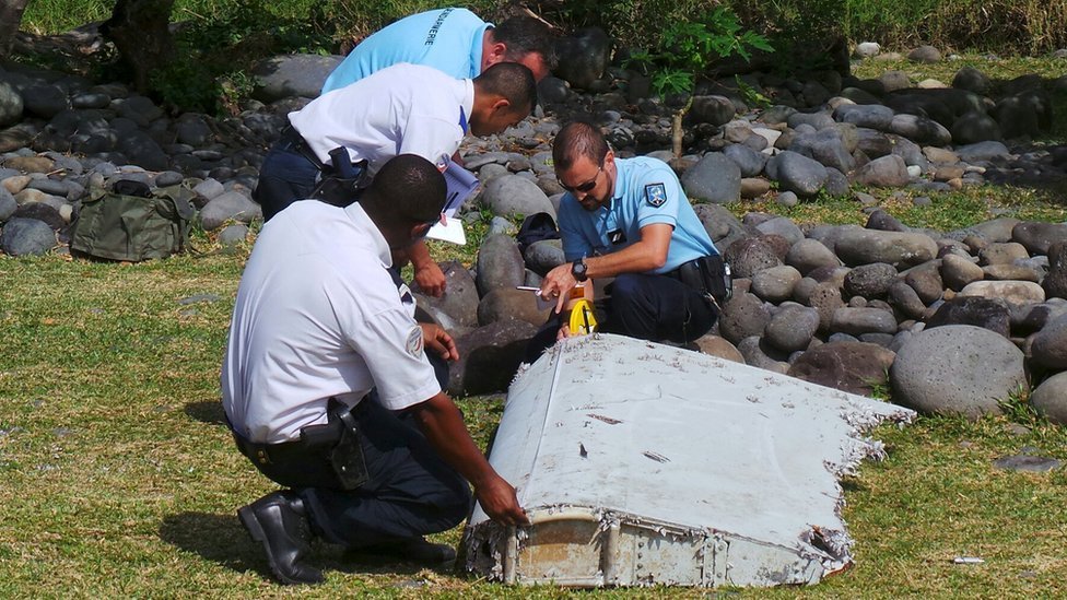 Oficiales de policía insepccionan un resto del avión encontrado en la isla de La Reunión, en el Océano Índico.